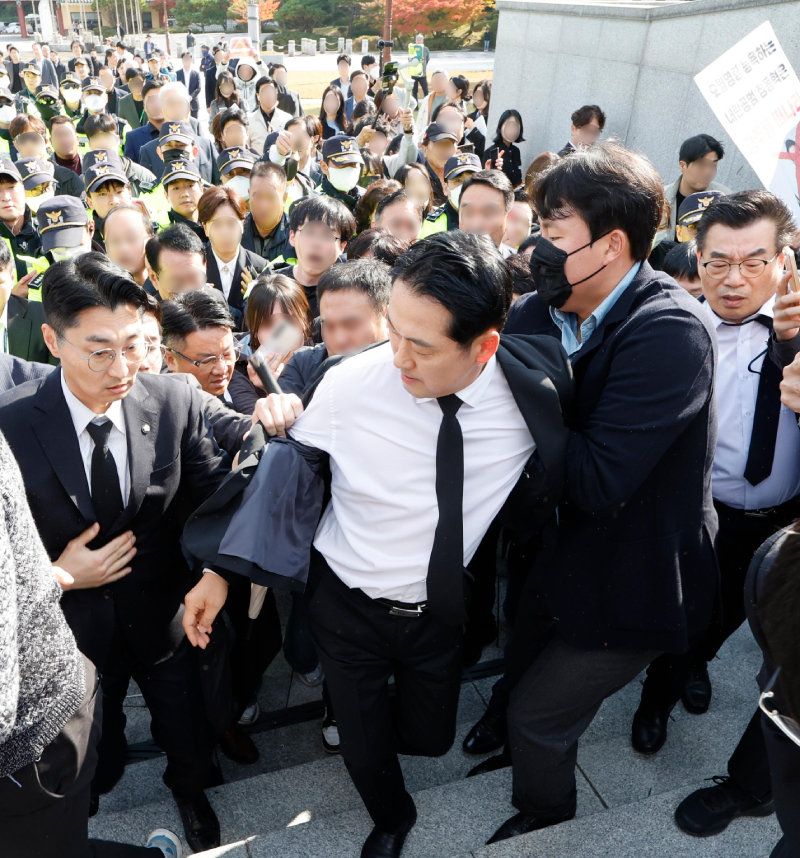 6일 광주를 방문한 국민의힘 장동혁 대표가 국립5·18민주묘지를 참배하기 위해 이동하고 있다. 이날 장 대표는 시위대의 저지를 뚫고 가까스로 추모탑에 도착했지만, 시민단체의 반발이 계속되면서 헌화와 분향을 하지 못한 채 발길을 돌렸다. 광주=뉴스1