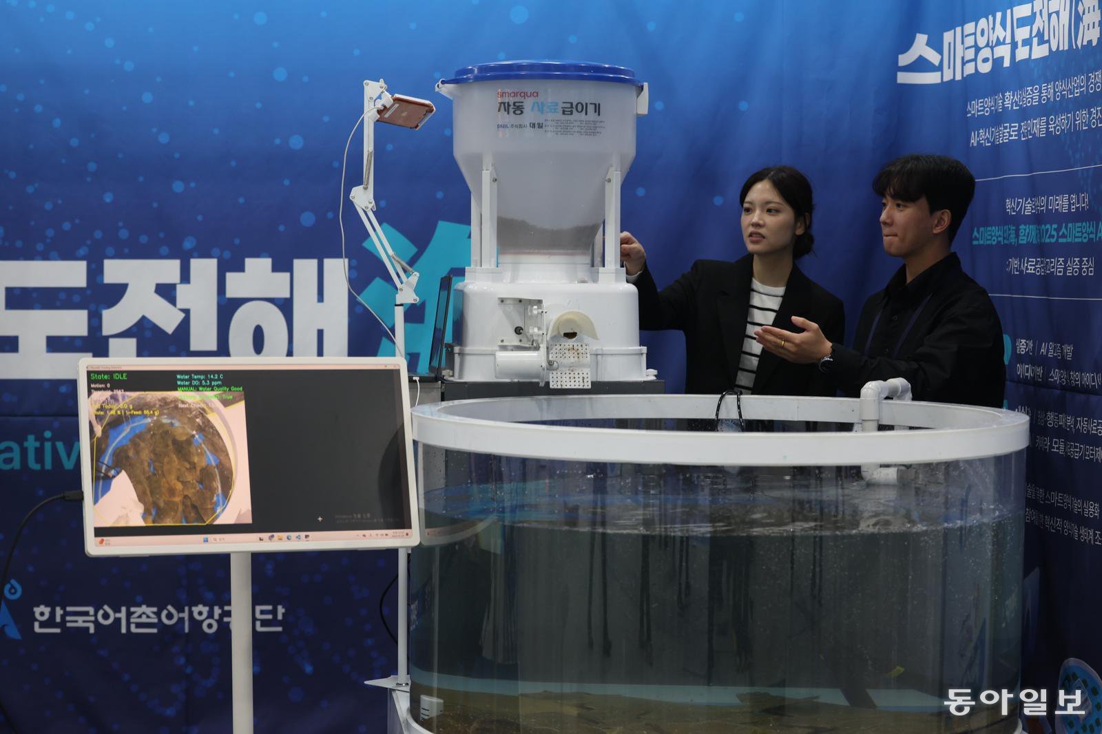 7일 오전 서울 양재동 aT센터에서 열린 ‘2025 씨팜쇼’에서 한 관람객이 AI 자동 급식 기계에 대한 설명을 듣고 있다. 	송은석 기자 silverstone@donga.com
