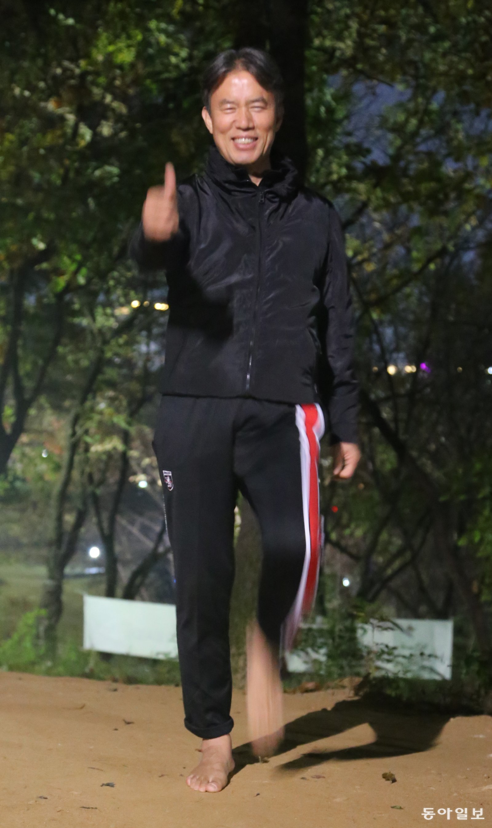 박경운 경감이 밤에 집 근처인 경기 파주 운정호수공원에서 맨발 걷기를 하며 엄지척하고 있다. 파주=양종구 기자 yjongk@donga.com