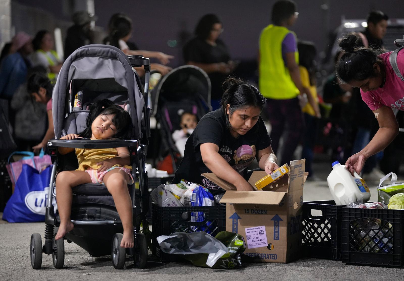 4일(현지 시간) 미 텍사스주 오스틴의 푸드뱅크에서 한 여성이 유모차에서 자고 있는 딸과 함께 식료품을 받고 있다. 연방정부 셧다운(업무 일시 중단)이 장기화하면서 저소득층 대상 식비 지원 프로그램(SNAP) 지원이 중단된 후 식료품 배급 수요가 급증하고 있다. 2025.11.07 오스틴=AP/뉴시스