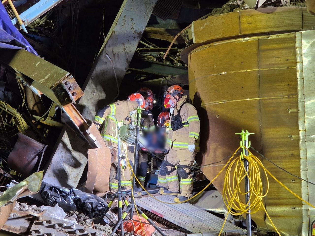 11일 울산화력발전소 보일러 타워 5호기 붕괴 현장에서 추가로 발견된 매몰 근로자 시신을 소방대원들이 수습하고 있다. 울산소방본부 제공