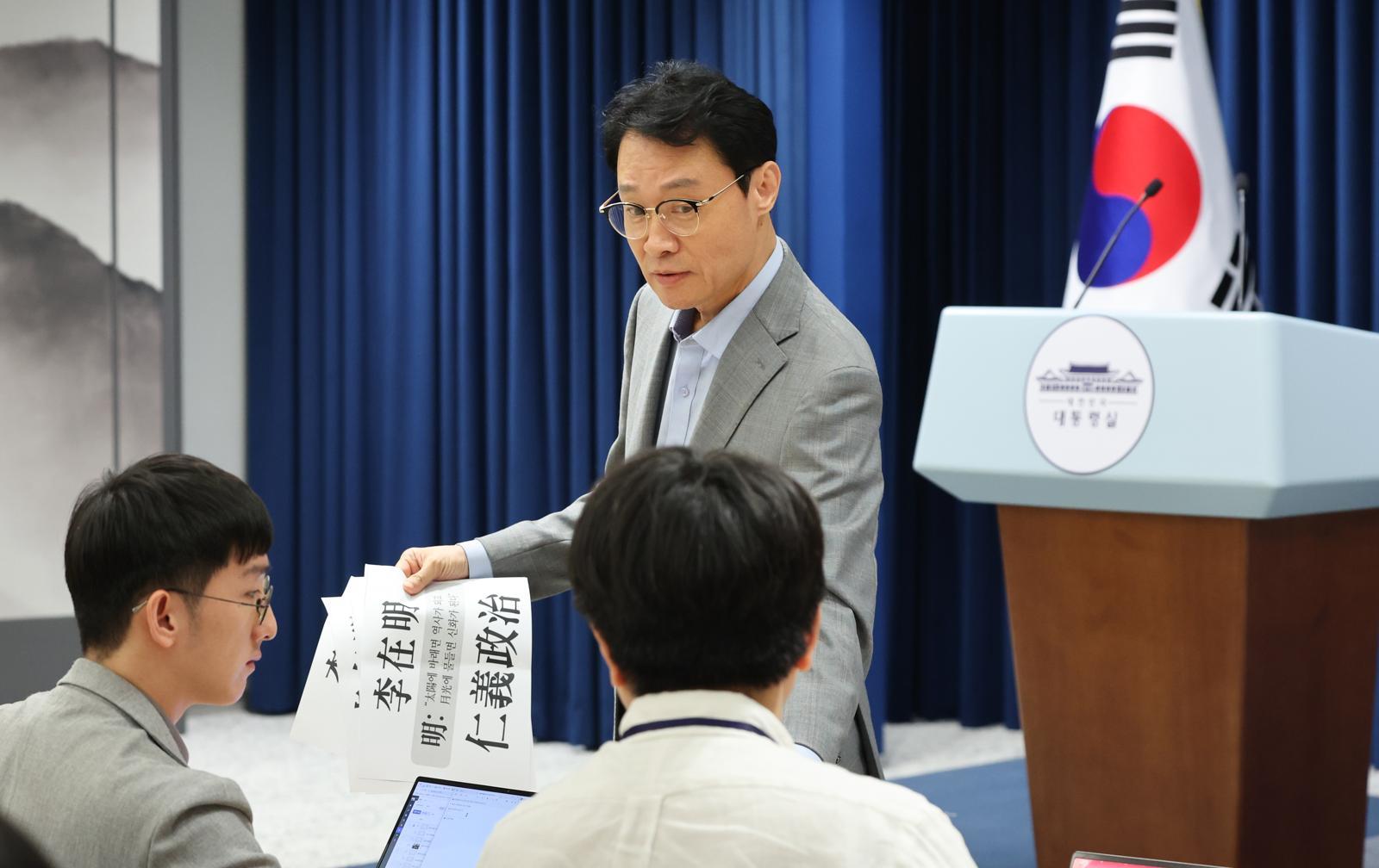 이규연 대통령실 홍보소통수석이 기자들에게 소설가 이병주의 글귀를 나눠주고 있다. 이 글귀는 언론인 조갑제가 “이 대통령 이름에 명(明)자 처럼 밝게 일하는 모습이 좋다”며 소개한 문구인 ‘태양에 바래면 역사가 되고 월광에 물들면 신화가 된다’다. 출처=뉴스1