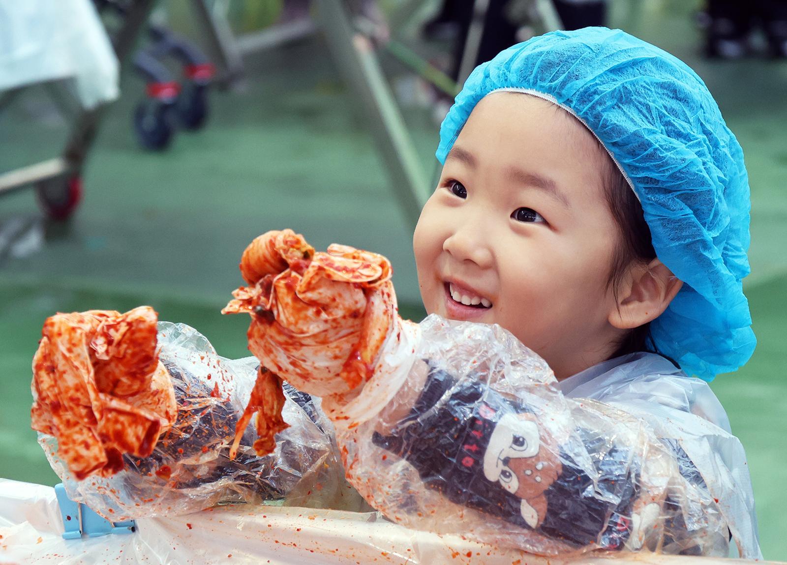 14일 강원 평창군 진부면민체육공원에서 열리고 있는 ‘제8회 평창고랭지김장축제’에서 부모와 함께 축제장을 찾은 어린이가 김장체험을 하고 있다. 평창군 제공