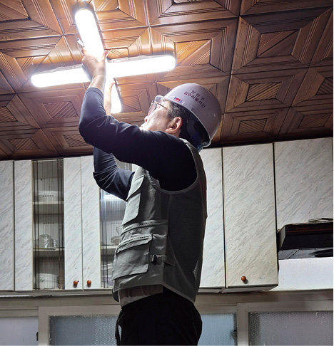 전등을 교체 중인 집수리 봉사단원. 양천구 제공