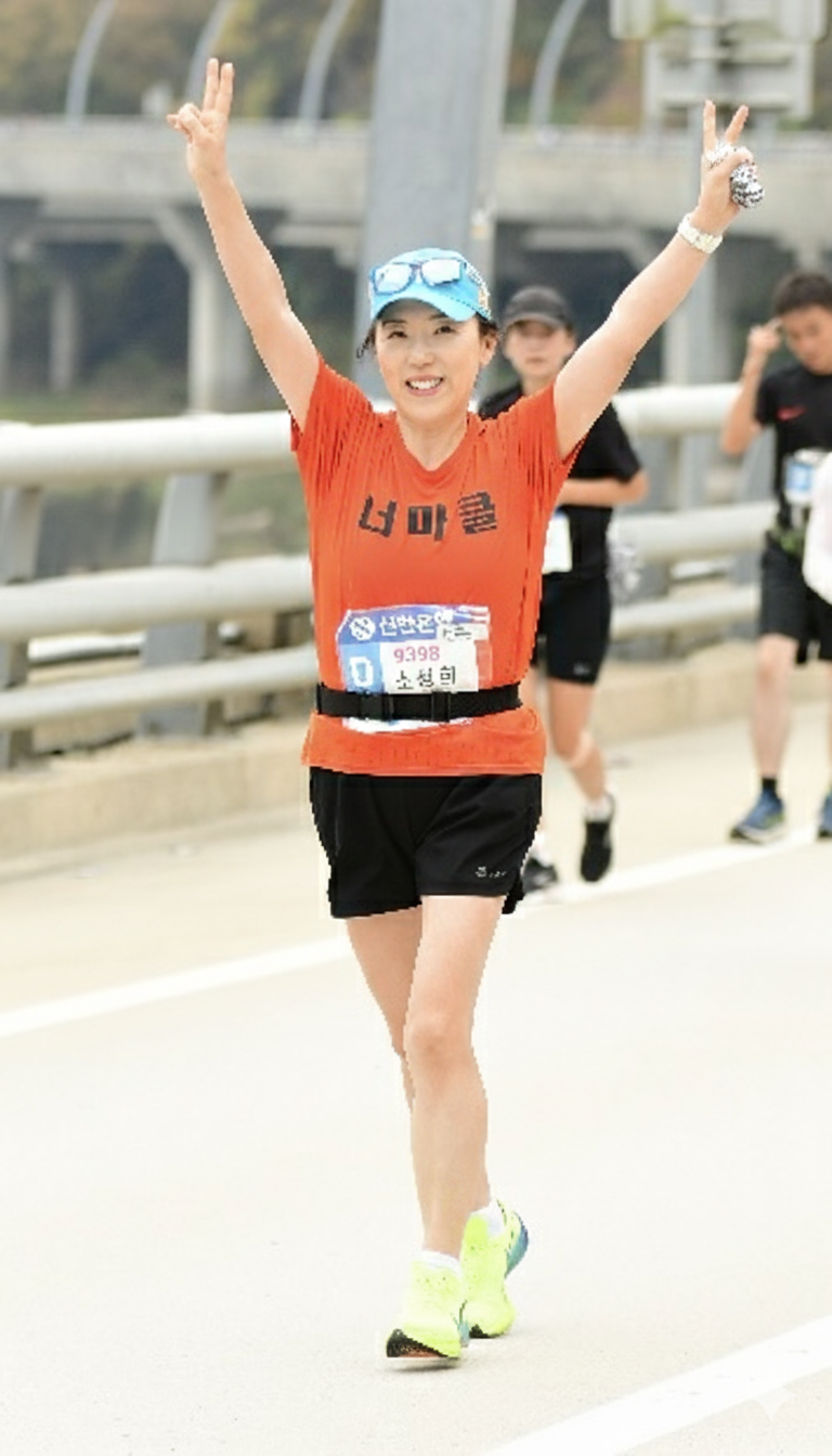 소성희 강사가 지난해 10월 열린 춘천마라톤 42.195km 풀코스를 달리다 두 팔을 들어 올리고 있다. 소성희 강사 제공.