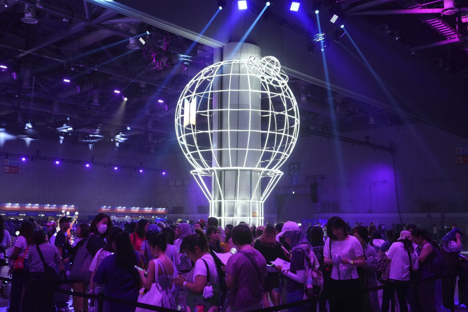 K-pop 그룹 BTS의 팬들이 고양시에서 열린 BTS 데뷔 기념 연례 행사인 ‘2025 BTS 페스타’ 기간 동안 아미 밤(ARMY Bomb) 근처에서 사진을 찍기 위해 기다리고 있다. AP/뉴시스