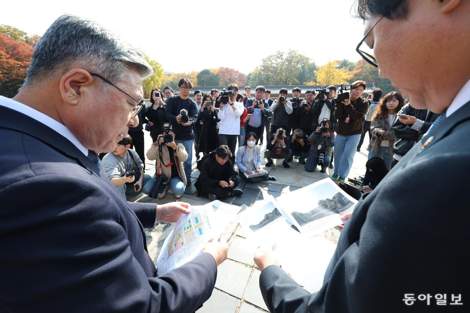 7일 오후 서울 종묘 앞에서 최휘영 문화체육관광부 장관과 허민 국가유산청장이 서울시의 종묘 앞 개발에 대한 입장을 밝히고 있다. 서울시는 최근 세운4구역 재개발지구의 높이 규제를 완화했다. 장관과 청장이 들고 있는 자료집에는 종묘 부속 건물 뒤로 바로 고층 빌딩이 보이는 사진이 부각되어 있다.  변영욱 기자 cut@donga.com