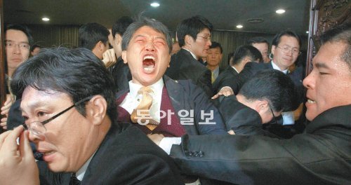 김선동 전 민주노동당 김선동 의원이 2011년 11월 22일 국회 본회의장에서 한미 자유무역협정(FTA) 비준동의안 처리에 반대하며 최루탄을 터뜨린 뒤 국회 경위들에 의해 본 회의장 밖으로 끌려나오고 있다. 변영욱 기자 cut@donga.com.