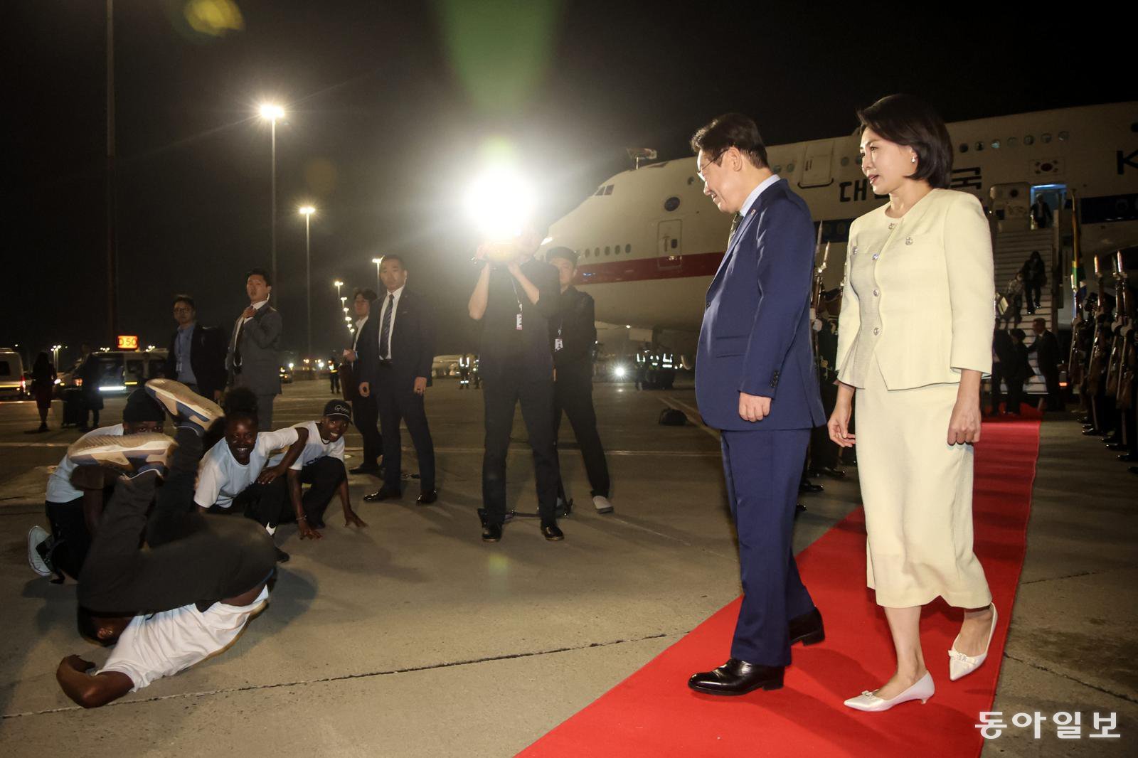 G20 정상회의에 참석하는 이재명 대통령과 김혜경 여사가 21일(현지 시간) 남아프리카공화국 요하네스버그 O.R. 탐보 국제공항에 도착해 공군1호기에서 내려 환영공연을 보고 있다. 요하네스버그=송은석 기자 silverstone@donga.com
