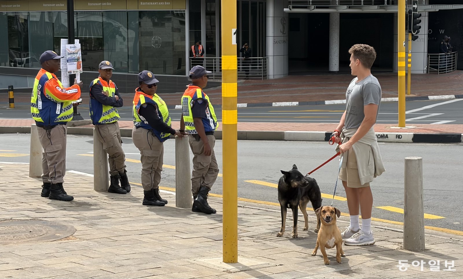 23일(현지시간) 남아공 요하네스버그 근교 샌튼에서 개 산책을 시키는 시민이 경찰들과 대화를 나누고 있다. 요하네스버그=송은석 기자 silverstone@donga.com