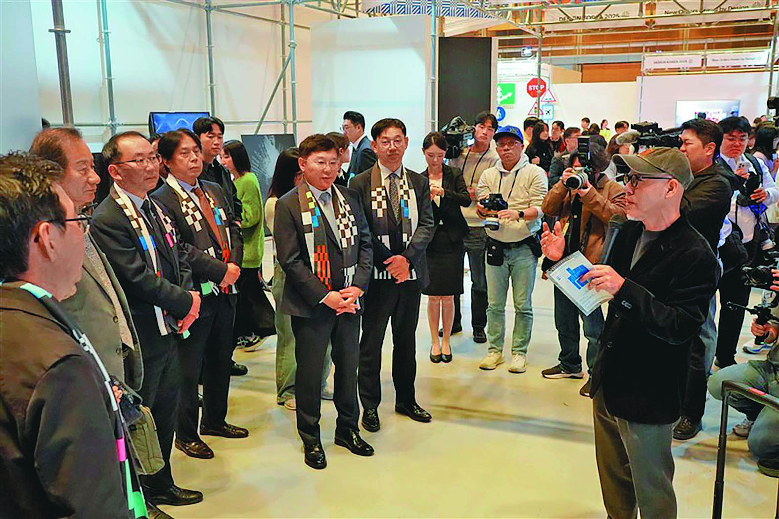 디자인코리아 2025 전시장을 찾은 관계자들이 주요 작품과 기술설명을 들으며 현장을 둘러보고 있다.