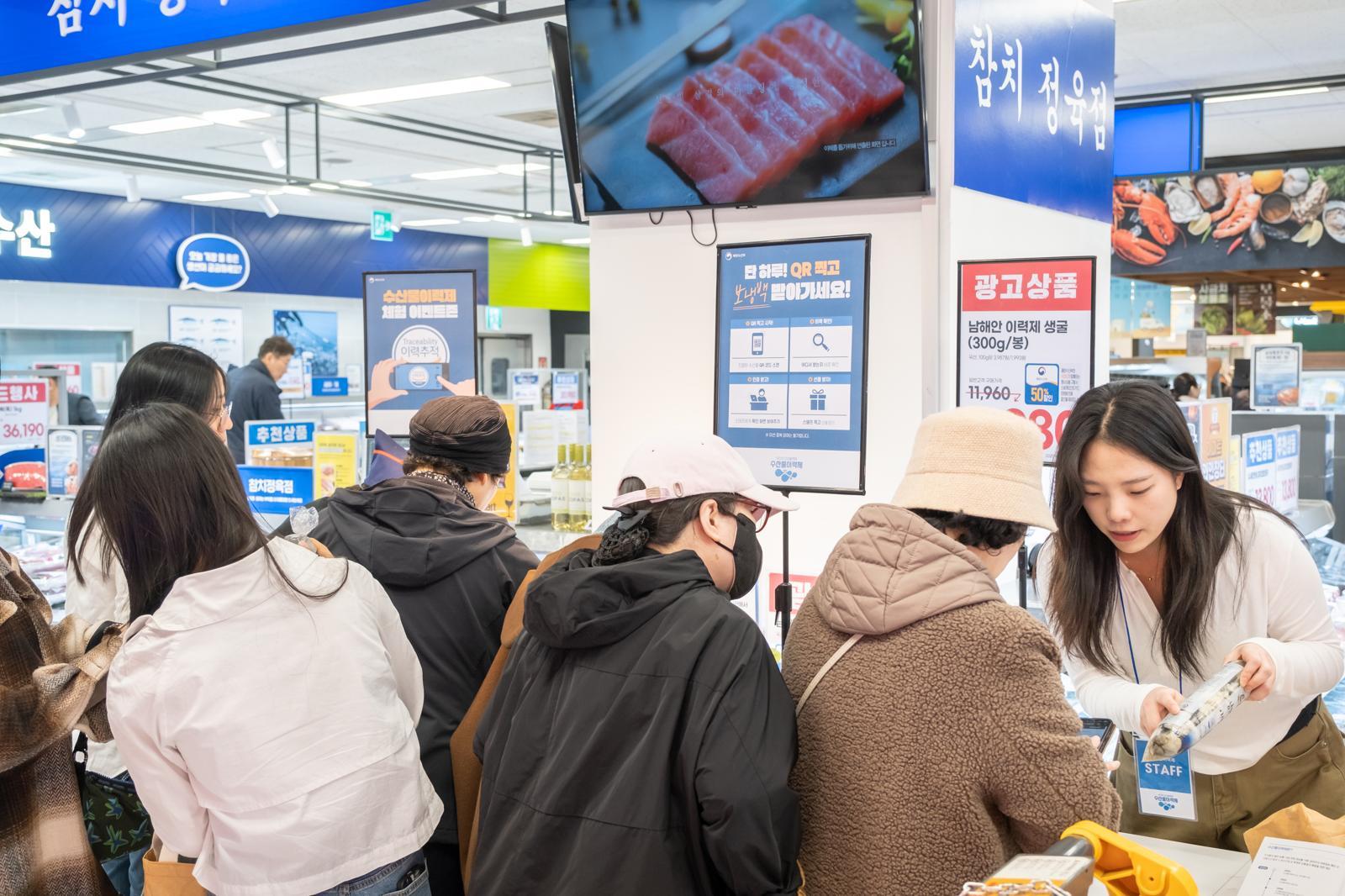 수산물이력제 행사장에서 체험에 참여하고 있는 고객들. QR코드를 통해 모바일로 직접 수산물이력제를 체험하는 모습(작은 사진). 해양수산부 제공