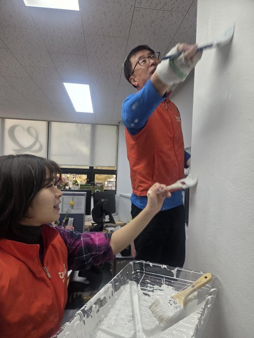 우체국금융개발원 윤창배 처장(사진 오른쪽)이 영등포좋은나무 공부방 페인트 봉사를 진행하고 있다. 사진 제공=우체국금융개발원