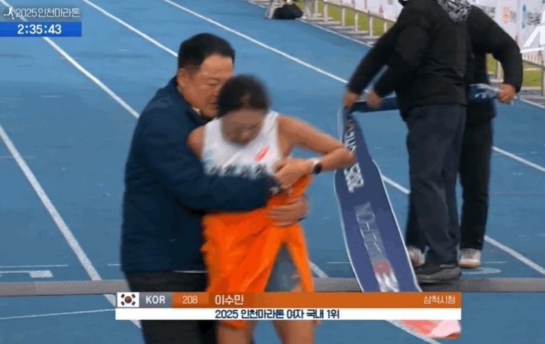 ‘2025 인천국제마라톤’에서 김완기 삼척시청 감독이 1위로 결승선에 들어온 이수민 선수를 부축하는 장면. 뉴스1