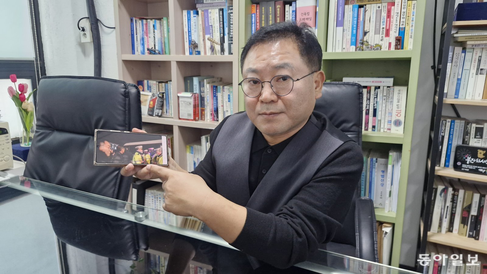 12·3 계엄 당시 국회 앞에서 군용 버스를 막아섰던 한광섭(56) 행정사가 1년 전 촬영한 사진을 보여주며 상황을 설명하고 있다. 한 씨는 “누군가 ‘(군인이 탄) 버스 문을 못 열게 막자’고 외치자 순식간에 시민들이 스크럼을 짰다”며 “국가적 위기 때마다 발휘되는 시민들의 응집된 힘을 다시금 확인한 순간이었다”고 말했다. 최효정 기자 hyoehyoe22@donga.com