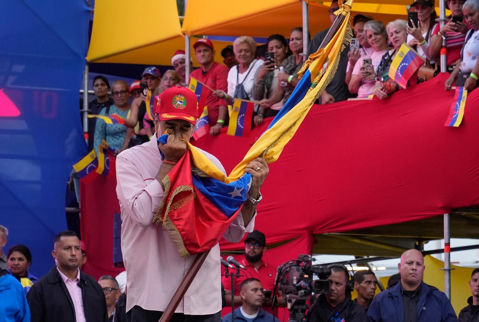 베네수엘라 국기에 입 맞추는 마두로 대통령
니콜라스 마두로 베네수엘라 대통령(맨 앞 모자 쓴 사람)이 1일 수도 카라카스의 대통령궁에서 열린 행사에서 자국 국기에 입을 맞추고 있다. 미국의 군사적 압박이 고조되는 가운데 마두로 대통령은 이날 대국민 연설에서 항전 의지를 강조했다. 최근 일부 미 언론들은 도널드 트럼프 미 대통령이 마두로 대통령에게 “즉각 사임하고 망명하라”는 최후통첩을 보냈다고 전했다. 카라카스=AP 뉴시스