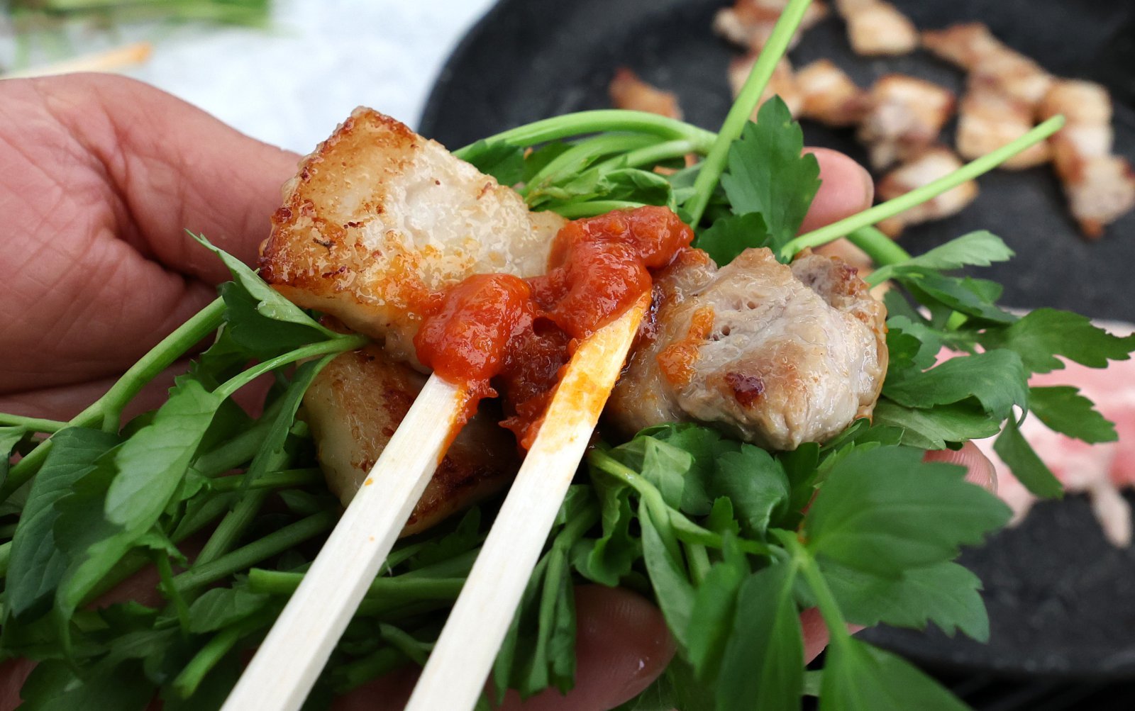 14일 대구 달서구 옛 두류정수장에서 열린 미나리·삼겹살 소비촉진 행사에서 시민들이 구매한 미나리와 삼겹살을 즉석에서 구워 맛보고 있다. 2025.03.14. [대구=뉴시스]