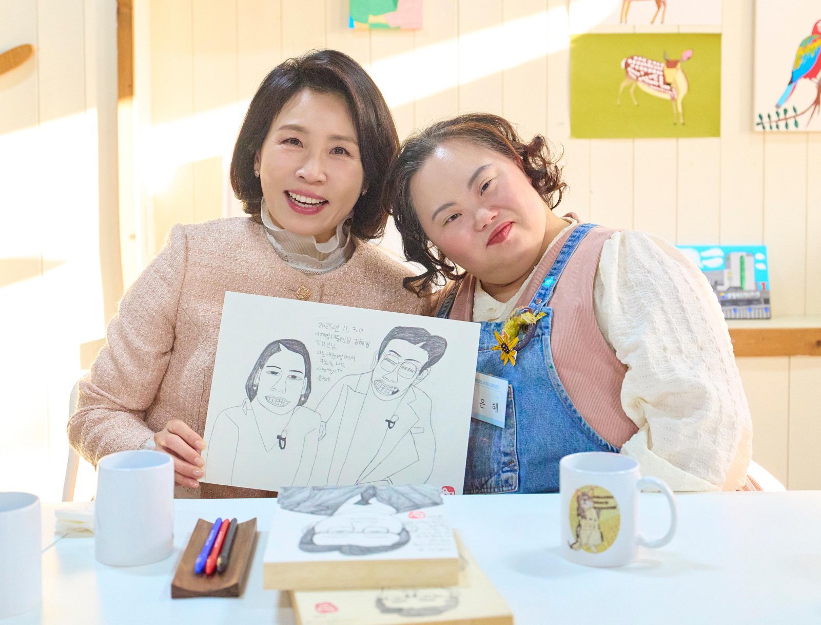 김혜경 여사가 3일 경기도 양평 어메이징 아웃사이더 아트센터에서 열린 정은혜 작가의 개인전 ‘은혜로운 명화전’을 찾아 작가와 기념촬영을 하고 있다. 2025.12.4 대통령실 제공