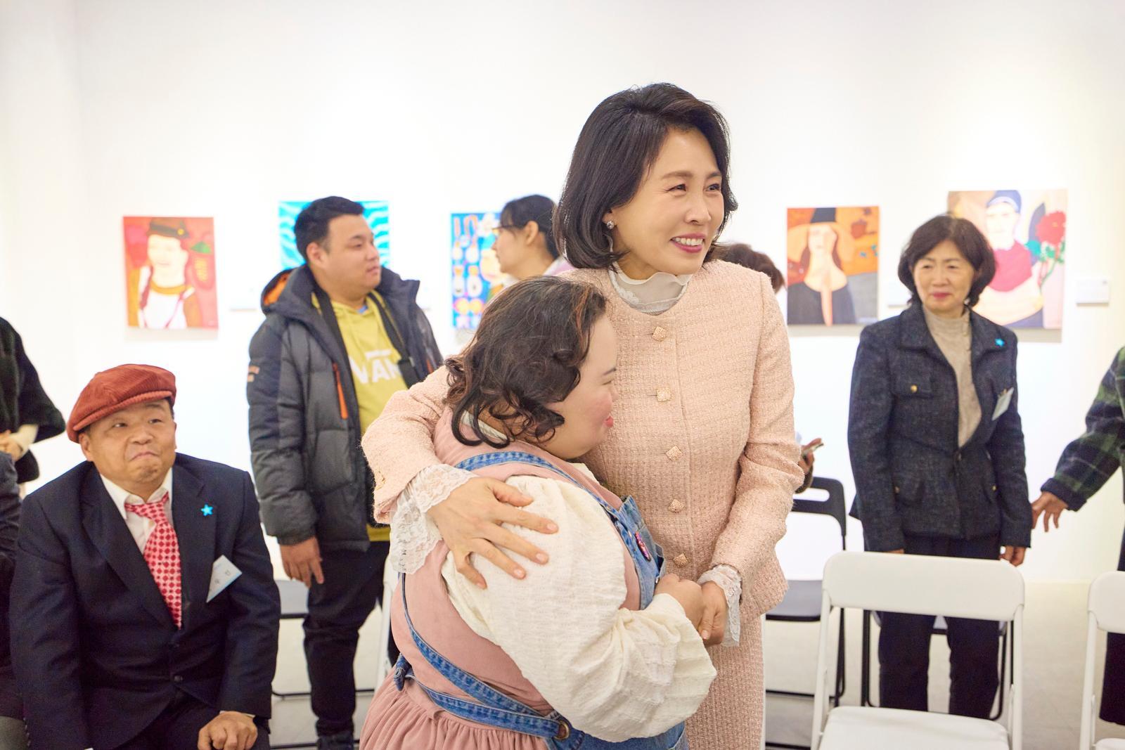 김혜경 여사가 3일 경기도 양평 어메이징 아웃사이더 아트센터에서 열린 정은혜 작가의 개인전 ‘은혜로운 명화전’을 찾아 작가와 포옹하고 있다. 2025.12.4. 대통령실 제공