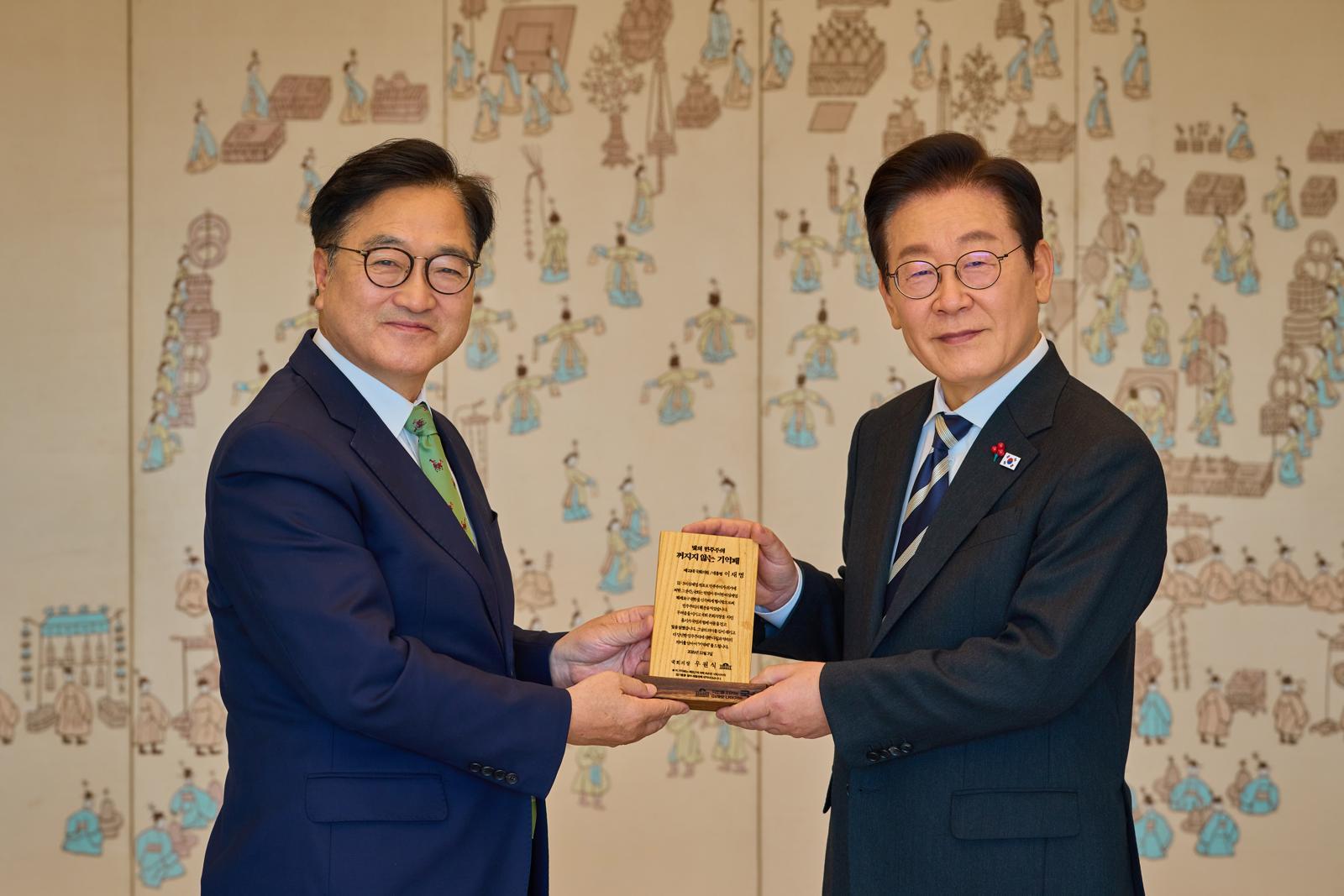 이재명 대통령이 3일 서울 용산 대통령실청사에서 열린 5부 요인 오찬에 참석한 우원식 국회의장으로부터 ‘빛의 민주주의 꺼지지 않은 기억패’를 선물받고 있다. 2025.12.3. 대통령실 제공