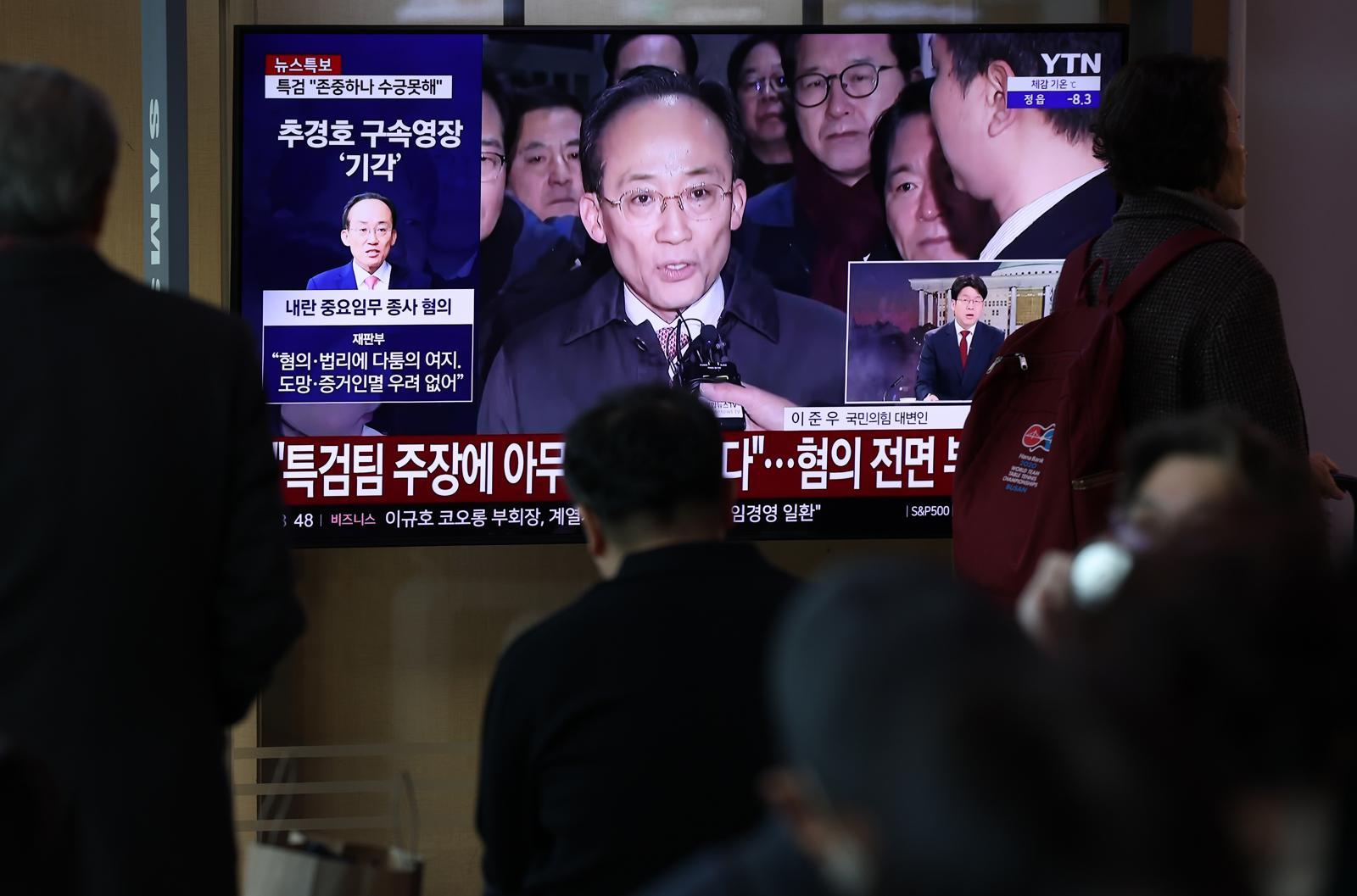 12·3 비상계엄 1년을 맞은 3일 오전 서울 중구 서울역 대합실에서 시민들이 비상계엄 해제 표결 참여를 방해한 혐의를 받는 추경호 국민의힘 의원의 구속영장 기각 관련 뉴스를 지켜보고 있다. 2025.12.3/뉴스1