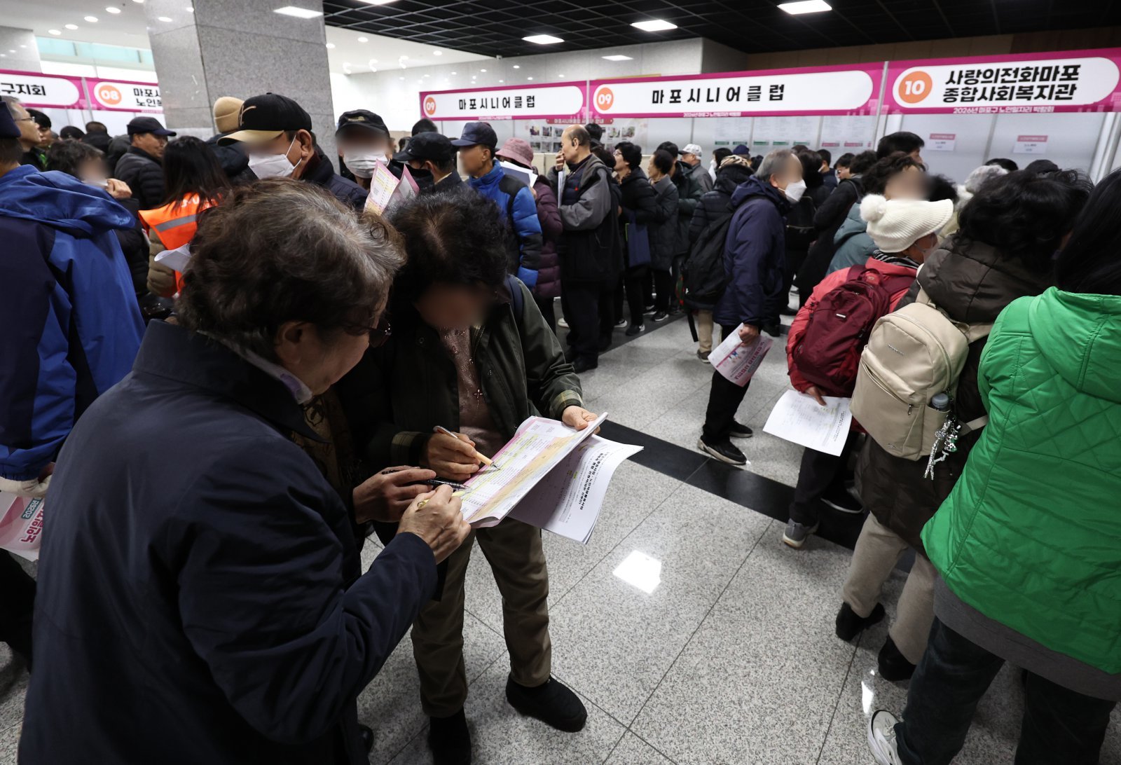 10일 오후 서울 마포구청에서 열린 노인일자리 박람회에서 어르신들이 참가업체 모집요강을 살펴보고 있다. 2025.12.10/뉴스1