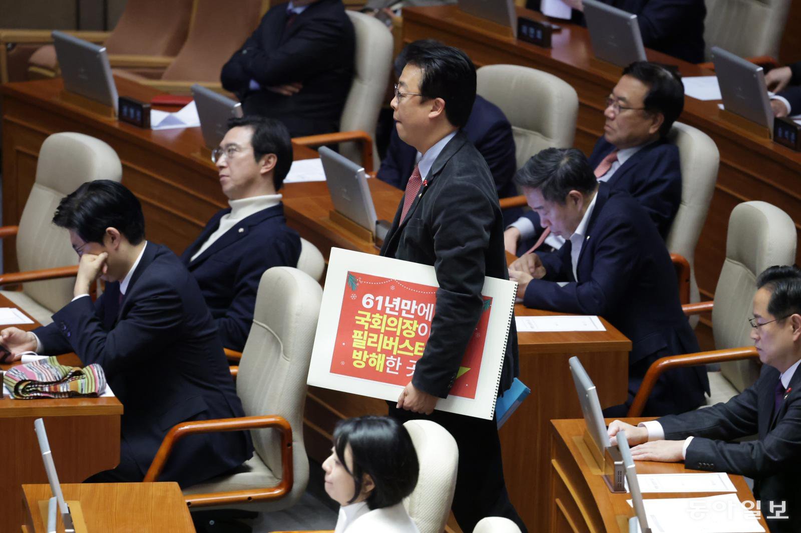 11일 국민의힘 곽규택 의원이 형사소송법 일부개정법률안이 상정되자 무제한 토론을 첫 주자로 나서기 위해 스케치북을 들고 단상으로 향하고 있다. 박형기 기자 oneshot@donga.com