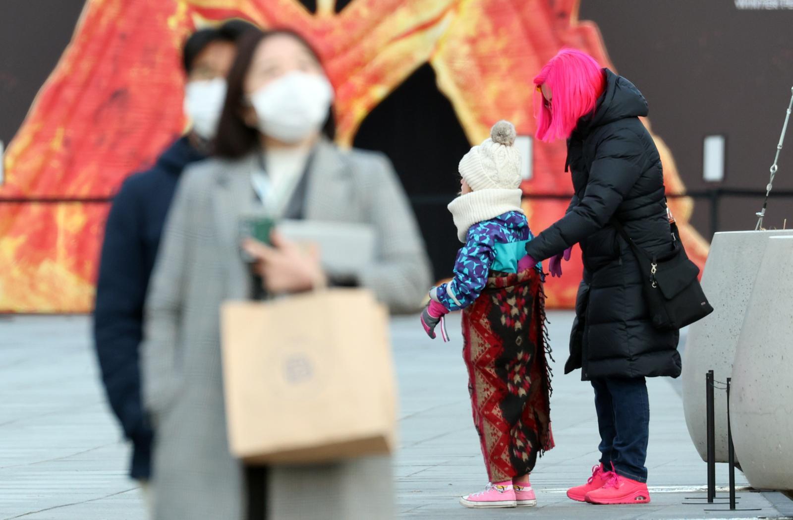 서울 광화문 네거리에서 외국인 관광객들이 잔뜩 움츠린 채 이동하고 있다. 2025.12.12 뉴스1