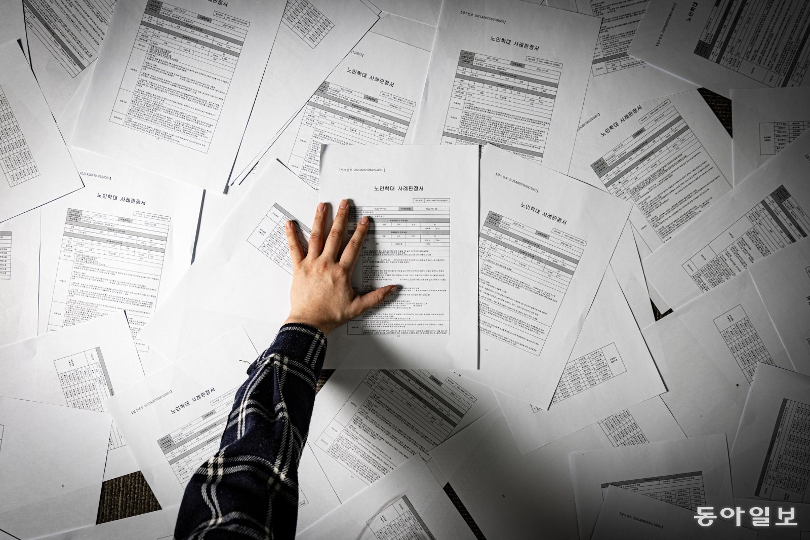취재팀이 ‘암수’(暗數) 치매 머니 사냥’의 기록이 담긴 노인보호전문기관의 경제적 학대 판정서를 살펴보고 있는 모습.