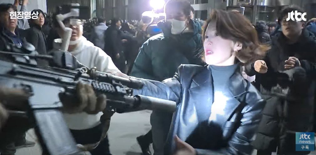 안귀령 대통령실 부대변인이 12·3 불법계엄 당시 계엄군 총기를 붙잡고 실랑이를 벌이는 모습. 뉴시스