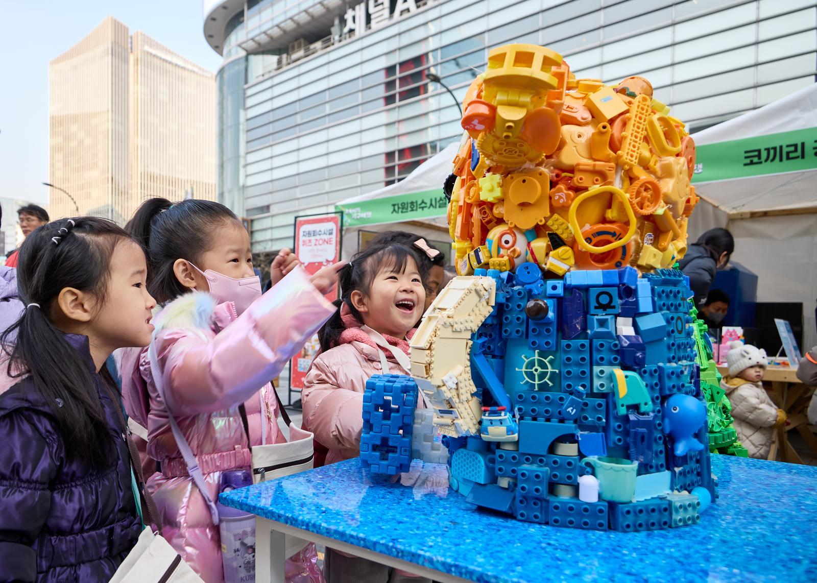 지난달 20일 서울 종로구 청계광장에서 열린 자원순환 행사 ‘초록이의 지구여행’에서 어린이들이 레고 블록 등 폐장난감으로 만든 조형물을 살펴보고 있다. 서울디자인재단 제공