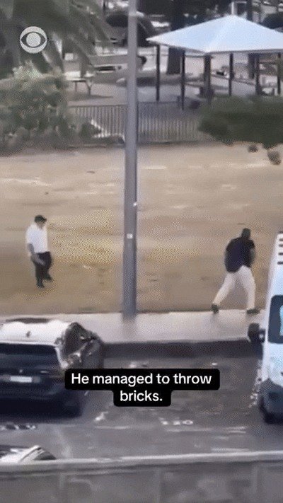 지난 14일 호주 시드니 테러 당시 시리아 출신 무슬림인 과일가게 주인 아흐메드가 총격범으로부터 총을 빼앗자 뒤따라 벽돌을 던져 총격범을 저지하는 루벤 모리슨의 모습. 출처=CBS 뉴스 페이스북