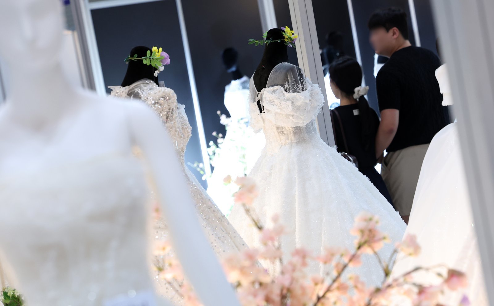 지난 7월 6일 서울 강남구 삼성동 코엑스에서 열린 2025 추계 웨덱스 웨딩 박람회에서 예비 부부들이 전시된 드레스를 살펴보고 있다. 2025.7.6 뉴스1