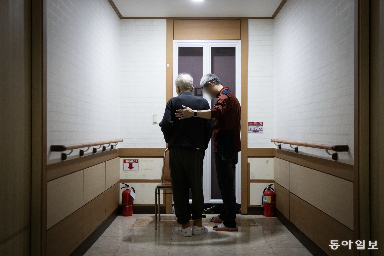 지난달 19일 요양원을 배회하는 치매 환자를 요양보호사가 병실로 인도하고 있다. 전국의 치매 환자 약 31만 명이 요양시설에서 지내고 있다.