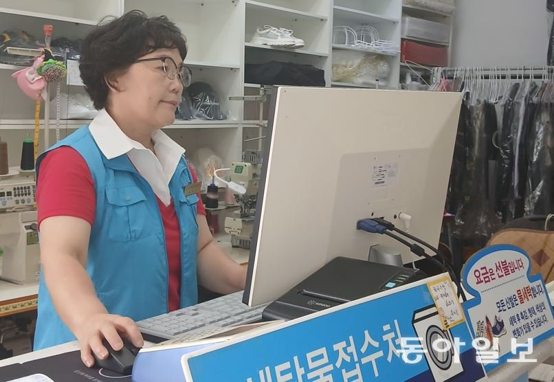 자신의 세탁소에서 세탁물을 접수하고 있는 용성옥 씨.