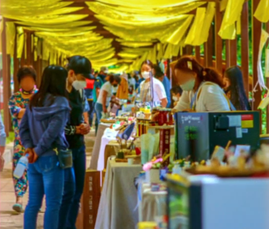 곡성역 앞 뚝방로에서 매주 토요일 열리는 뚝방마켓. 임원자 대표가 10년간 지켜온 이 공간은 노란 천막 아래에서 장터이자 문화 현장으로 자리 잡았다.