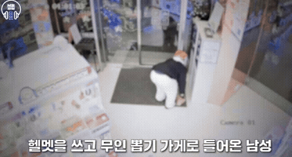 헬멧을 쓴 절도범이 미리 준비한 도구로 무인 뽑기방 지폐 교환기를 파손하는 모습. 서울경찰 유튜브 캡처