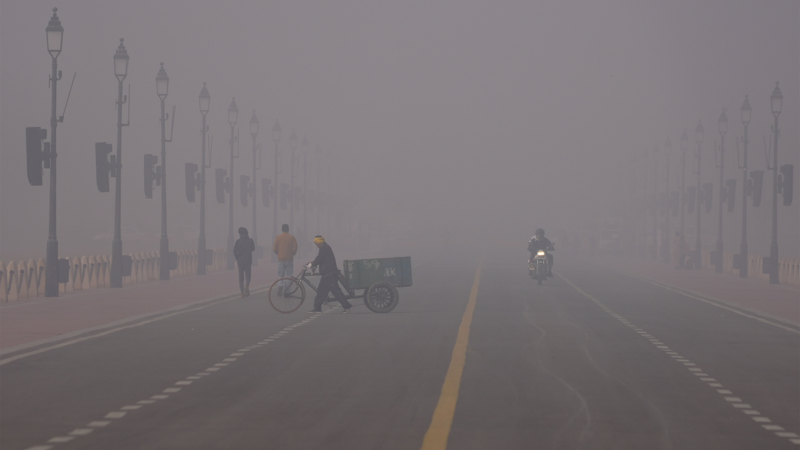 스모그로 뒤덮인 인도 뉴델리의 아침에 한 남성이 자전거 수레를 밀고 가고 있다. AP/뉴시스
