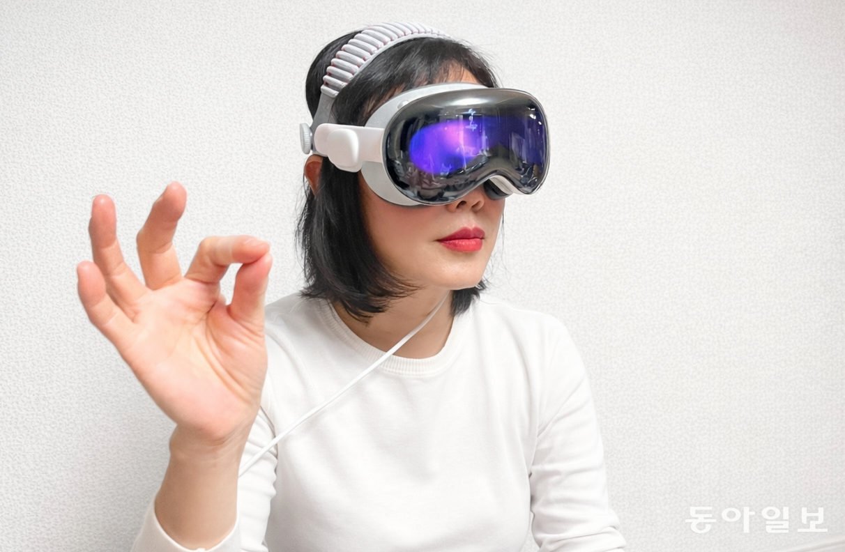 애플이 11월 한국에 출시한 비전프로(M5 칩 탑재 모델)를 쓴 채 손가락을 집어 감상할 영상을 선택하고 있는 주부 최민선 씨. 최 씨는 “사막을 걷는 영상을 틀었는데, 현장감이 너무 생생한 나머지 방 안에 있는 걸 깜빡하고 모래를 만져보고 싶어서 손을 뻗어 바닥을 만지기도 했다”고 체험 소감을 밝혔다. 애플에 따르면 기존 비전프로보다 M5 칩 탑재 모델은 전반적인 구동 속도가 더 빠르고 작동이 부드럽다. 이민아 기자 omg@donga.com