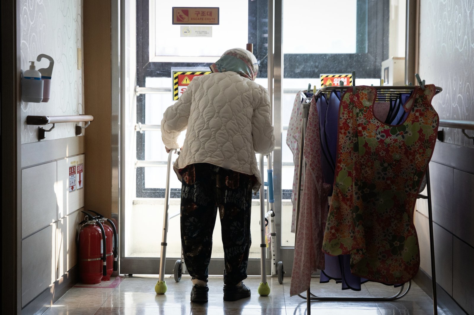 치매노인 김연순 씨가 보행보조기에 의지해 복도를 배회하고 있다.