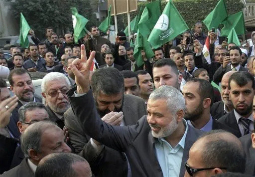 2011년 12월 이집트 수도 카이로를 방문한 당시 하마스 최고지도자 이스마일 하니예(앞줄 오른쪽에서 두 번째)가 시민들의 환호에 손가락으로 승리를 뜻하는 ‘V’자를 그리며 화답하고 있다. 하니예의 뒤로 이집트에서 태동한 이슬람 원리주의 단체 ‘이슬람형제단’의 녹색 깃발이 보인다. 하마스는 출범 때부터 자신을 무슬림형제단의 팔레스타인 지부로 규정하며 긴밀한 관계를 맺고 있다. 카이로=AP 뉴시스