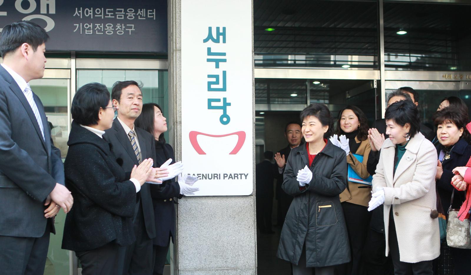 2012년 2월 16일 새누리당 당시 박근혜 비상대책위원장이 서울 영등포구 여의도 새누리 당사에서 열린 새누리당 현판식에서 당명 제안자인 김성준, 최유경 씨등과  함께 새당명이 새겨진 현판을 당사 외부 벽에 걸고 있다. 동아일보 DB