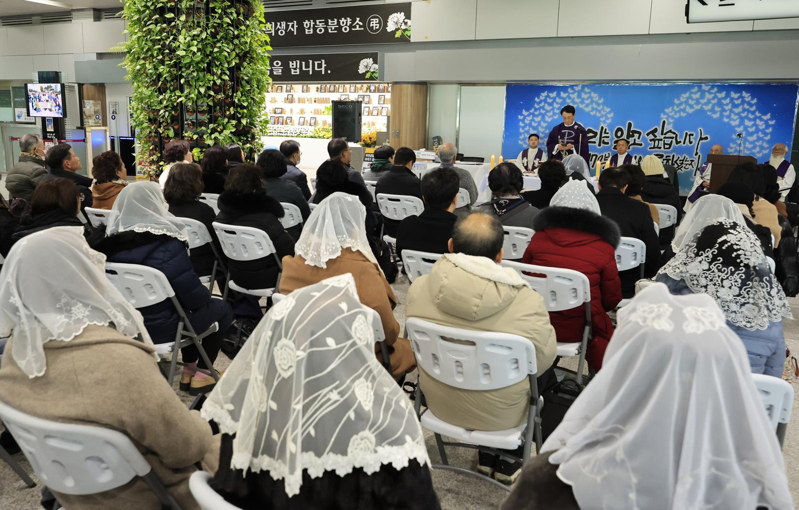 제주항공 여객기 참사 1주기를 앞둔 21일 전남 무안국제공항 1층 대합실에서 희생자 유가족들과 추모객들이 천주교 추모미사를 하고 있다. 무안=박영철 기자 skyblue@donga.com