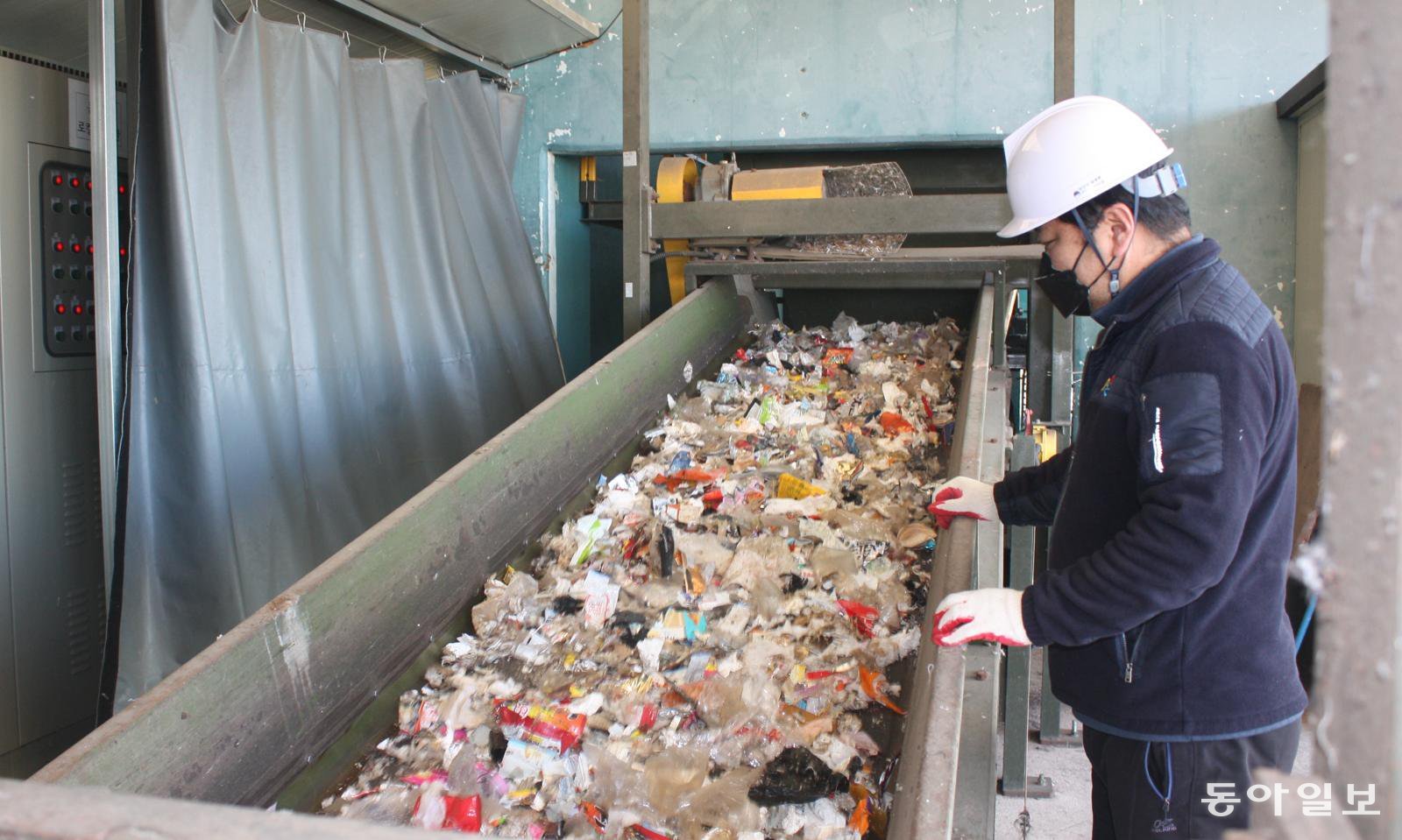 강원 고성군 죽왕면 생활폐기물 전처리 선별 시스템 처리장에서 관계자가 선별기를 거쳐 분류된 폐비닐이 컨베이어벨트를 따라 이동하는 모습을 지켜 보고 있다. 고성=이인모 기자 imlee@donga.com