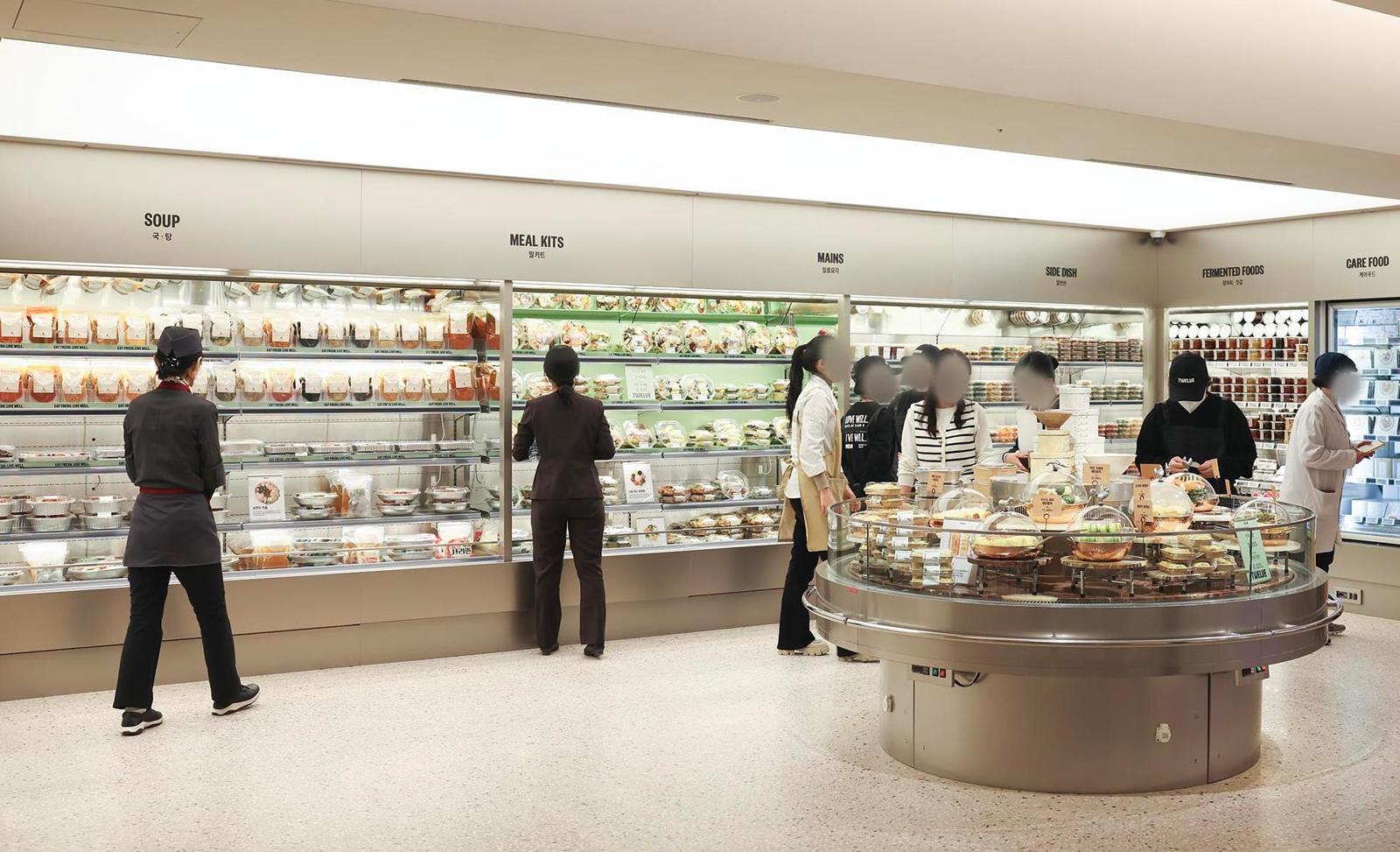 서울 강남구 청담동에 문을 연 ‘하우스오브신세계 청담’ 식품관 ‘트웰브’의 ‘홈밀’ 코너에서 방문객들이 밀키트와 장아찌, 국 등을 둘러보고 있다. 신세계백화점 제공