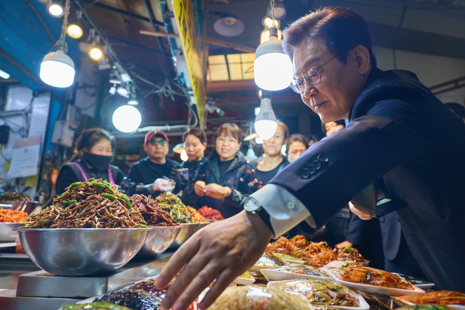 이재명 대통령이 23일 부산진구 부전시장을 방문해 반찬을 고르고 있다. 대통령실 제공