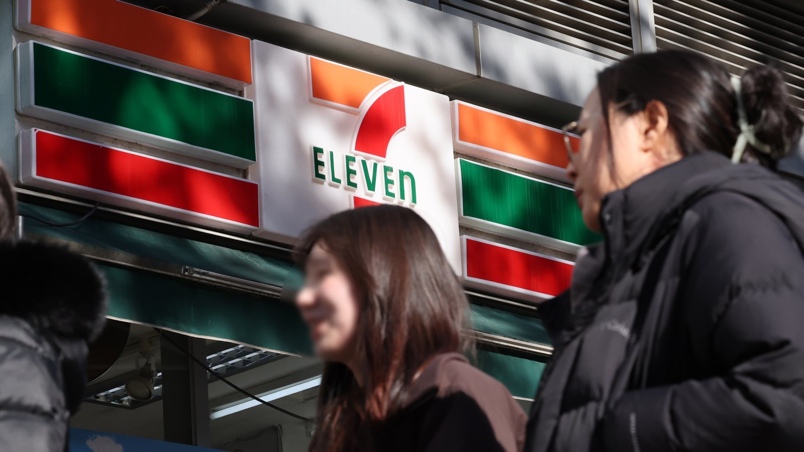 22일 서울 시내 세븐일레븐 편의점 앞으로 시민들이 이동하고 있다.   편의점 세븐일레븐은 내년부터 PB(자체브랜드) 제품 가격을 대거 인상한다. 최근 인건비와 원부자재 가격 인상으로 원가 부담이 심화한 데 따른 것으로 풀이된다. 2025.12.22. [서울=뉴시스]