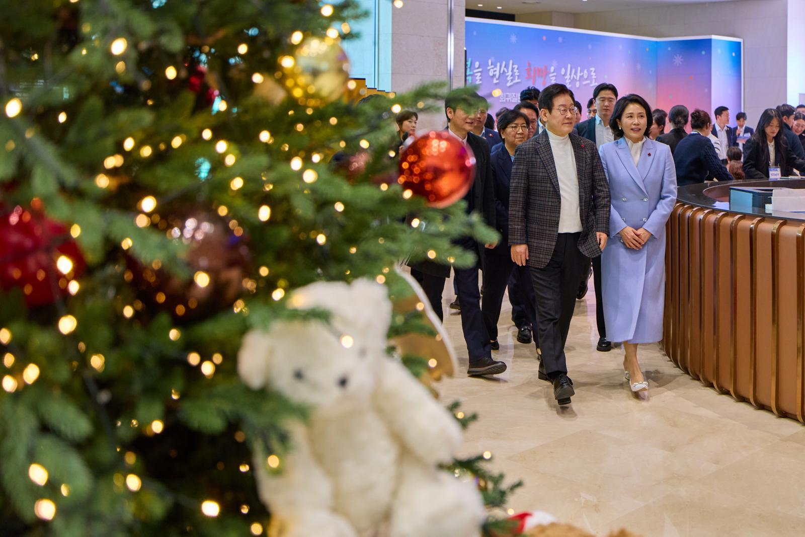 이재명 대통령과 김혜경 여사가 24일 서울 서대문구 신촌세브란스 연세암병원 중입자치료센터에서 진행된 희귀질환 환우·가족 현장소통에서 크리스마스 트리 옆을 지나가고 있다. 2025.12.24. 이재명 대통령 SNS