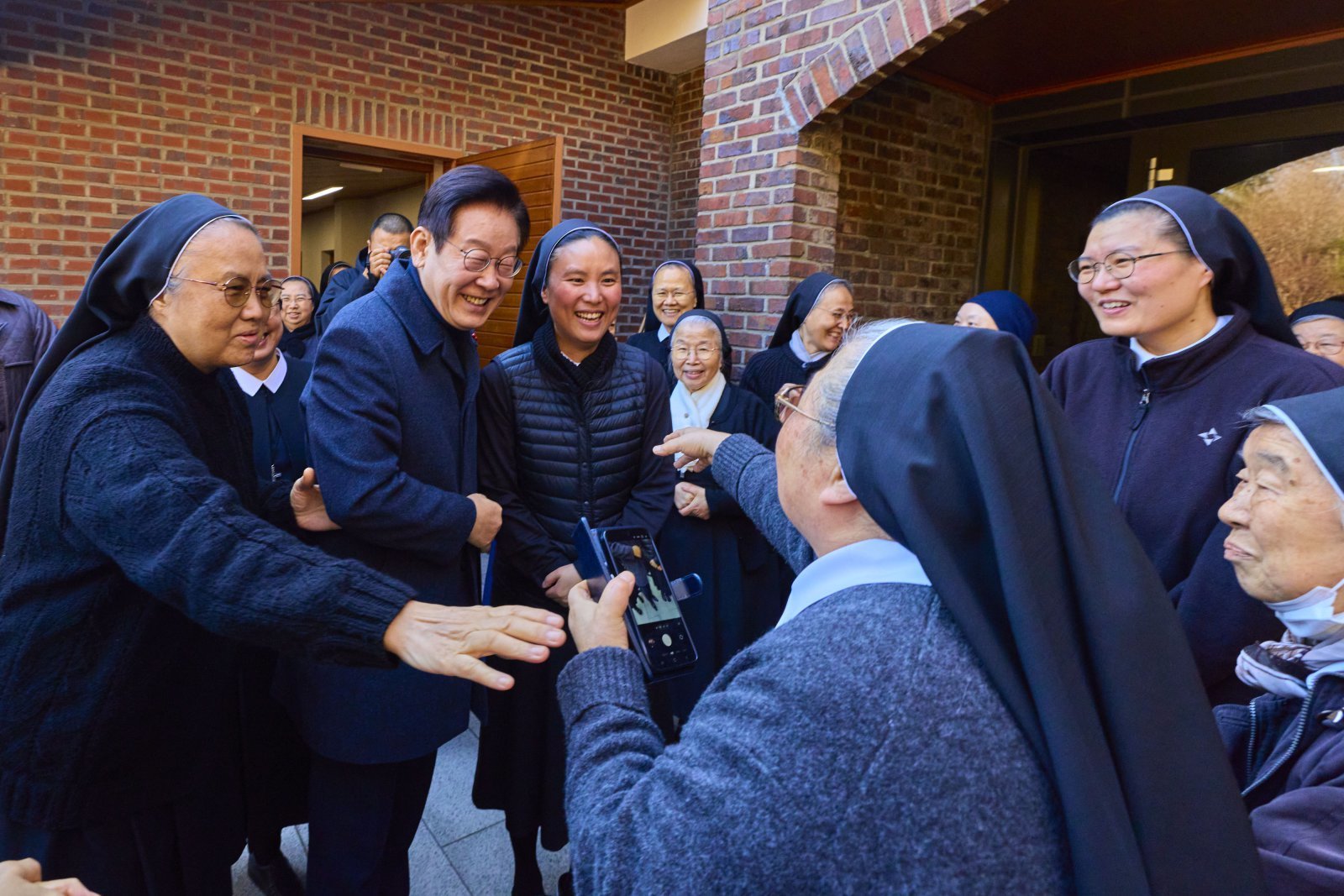 이재명 대통령이 25일 인천 계양구 노틀담 수녀원을 방문해 수녀들과 성탄 인사를 나누며 기념촬영을 하고 있다. 대통령실 제공