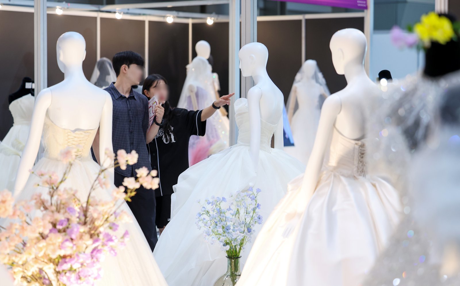 서울 강남구 삼성동 코엑스에서 열린 2025 추계 웨덱스 웨딩 박람회에서 예비 부부들이 전시된 드레스를 살펴보고 있다. (자료사진) 2025.7.6 뉴스1